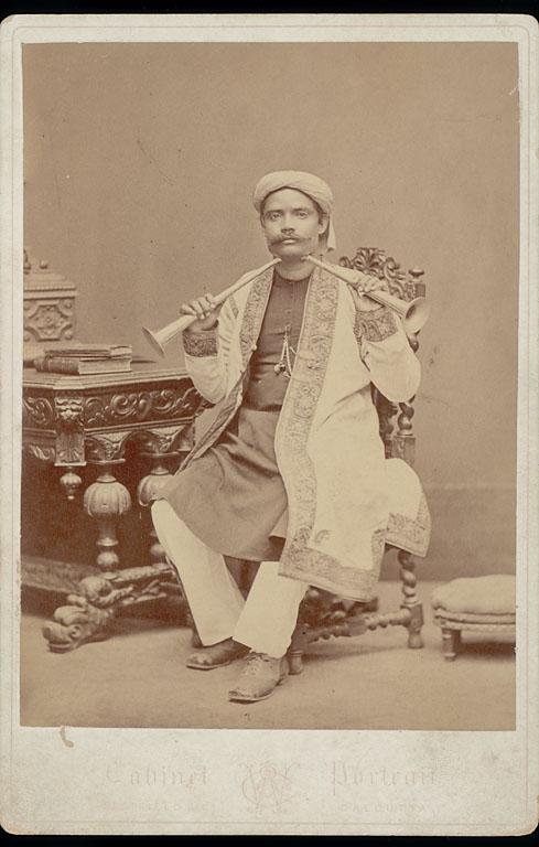 Bengali Man in Costume Holding Two Horns to Throat